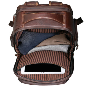A brown leather backpack shown open from a top-down view, revealing a striped interior lining and folded clothing inside, with a tablet partially visible in the lower compartment.